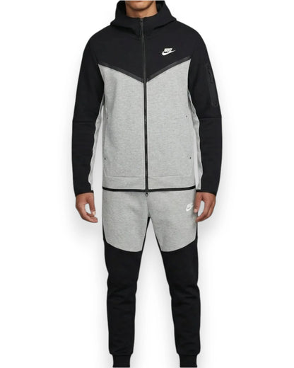 Person wearing a black and gray Nike tracksuit on a white background