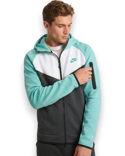 Man wearing a teal, white, and black Nike tracksuit on a white background